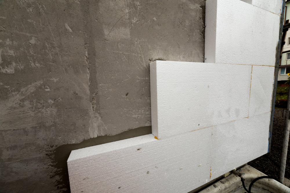 Close-up detail of plastered house wall with rigid styrofoam insulation. Modern technology, construction, renovation, energy saving, alternative for mineral wool, warm comfortable house concept. Placas EPS sistema ETICS.